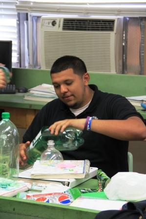 Senior Jose Palma assembles his decomposition bottle for AP Environmental Science on September 4. The students put vegetable and fruit scraps into the bottles and will watch them decompose and will collect data over a long period of time.