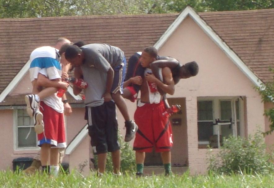 The basketball team players lift and carry each other for drills during conditioning.