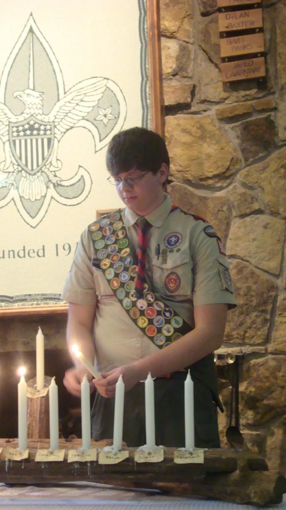 Senior Matt Gresham lights a candle during the Eagle Scout ceremony on August 31. Gresham received 41 merit badges as a Boy Scout, and completed his Eagle Scout project by building a large fence, picnic tables and benches for his church.