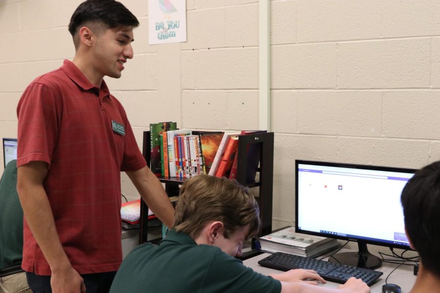 New computer science teacher Kevin Suarez works with a student. Suarez joined the staff after subbing last year.