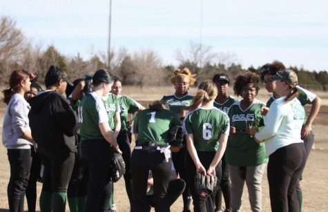 Coach Kristen Buckellew goes over plays with the softball team.