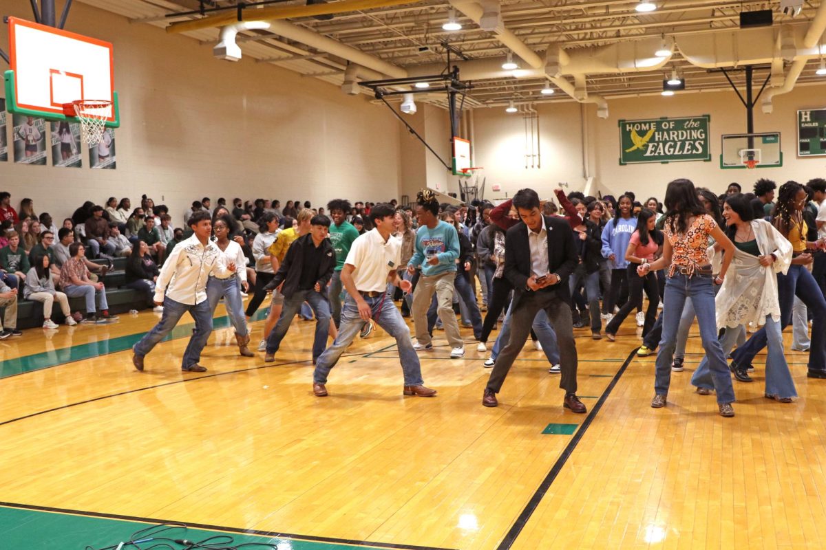 A large portion of the student body, accompanied by guests and teachers, dances on the gym floor during the Hispanic Heritage Week assembly in September 2022.